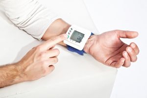 Photo of young man’s hand measuring his blood pressure