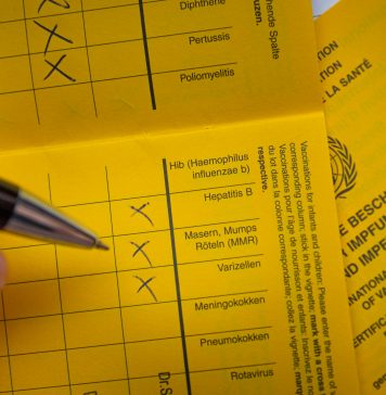 Ein Impfpass wird ausgefüllt.