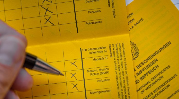 Ein Impfpass wird ausgefüllt.