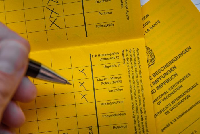 Ein Impfpass wird ausgefüllt.