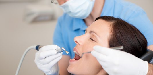 Zahnarzt behandelt eine entspannte Patientin.