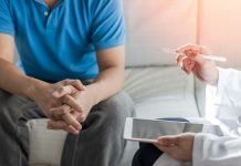 Ein Mann im Gespräch mit einer Ärztin oder einem Arzt – symbolisch für medizinische Beratung bei psychischen Erektionsstörungen und vertrauensvolle Hilfe bei sexuellen Problemen.