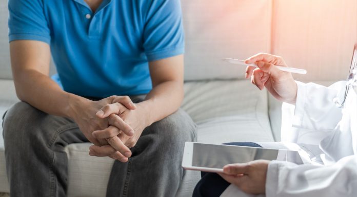 Ein Mann im Gespräch mit einer Ärztin oder einem Arzt – symbolisch für medizinische Beratung bei psychischen Erektionsstörungen und vertrauensvolle Hilfe bei sexuellen Problemen.