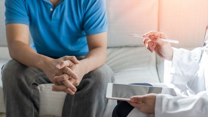 Ein Mann im Gespräch mit einer Ärztin oder einem Arzt – symbolisch für medizinische Beratung bei psychischen Erektionsstörungen und vertrauensvolle Hilfe bei sexuellen Problemen.