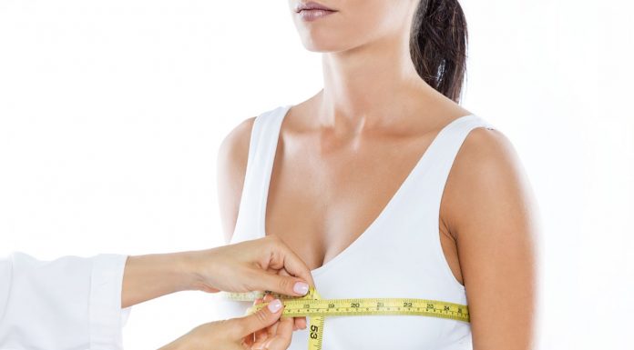 Vom Druck zur Leichtigkeit: Warum körperliche Veränderungen oft seelische Heilung bedeuten Ärztliches Fachpersonal misst den Brustumfang einer Frau mit Maßband zur Vorbereitung auf eine Brustverkleinerung oder medizinische Beratung. Fokus auf Anpassung der Brustgröße und körperliche Gesundheit.