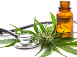 Cannabisblüte, Hanfblätter, braunes Ölfläschchen und Stethoskop als Symbolbild für medizinisches Cannabis und mögliche Anwendungen in der Schmerztherapie.