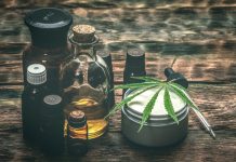 Verschiedene CBD-Produkte auf Holztisch, darunter Ölflaschen, Cremedose mit Hanfblatt und Pipette – Symbol für natürliche Anwendungen von Cannabidiol zur Unterstützung von Gesundheit und Wohlbefinden.