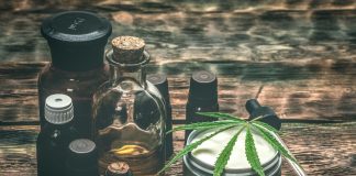 Verschiedene CBD-Produkte auf Holztisch, darunter Ölflaschen, Cremedose mit Hanfblatt und Pipette – Symbol für natürliche Anwendungen von Cannabidiol zur Unterstützung von Gesundheit und Wohlbefinden.