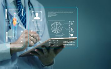 Arzt oder Ärztin hält ein Tablet, auf dem digitale Gesundheitsdaten wie Organmodelle und medizinische Grafiken angezeigt werden – symbolische Darstellung moderner telemedizinischer und digitaler Diagnostik.