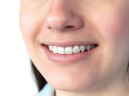 Nahaufnahme eines lächelnden Mundes mit weißen, gepflegten Zähnen und gesundem Zahnfleisch; zeigt ein natürliches Lächeln und dient zur Veranschaulichung von Mundgesundheit und guter Mundhygiene.