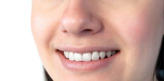 Nahaufnahme eines lächelnden Mundes mit weißen, gepflegten Zähnen und gesundem Zahnfleisch; zeigt ein natürliches Lächeln und dient zur Veranschaulichung von Mundgesundheit und guter Mundhygiene.