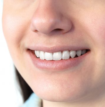 Nahaufnahme eines lächelnden Mundes mit weißen, gepflegten Zähnen und gesundem Zahnfleisch; zeigt ein natürliches Lächeln und dient zur Veranschaulichung von Mundgesundheit und guter Mundhygiene.