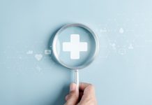 Hand hält eine Lupe über einem medizinischen Kreuz, umgeben von digitalen Gesundheitssymbolen als Motiv für Gesundheitsvorsorge und Prävention.