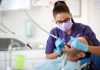 Gut vorbereitet auf einen Zahnarzteingriff: Was Patienten vorab wissen sollten Zahnmedizinische Fachkraft behandelt einen Patienten im Behandlungsstuhl als Illustration zur Vorbereitung auf einen geplanten Zahnarzteingriff.