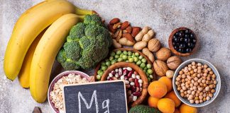 Magnesium bei Stress: Welche Rolle spielt der Mineralstoff für Nerven und Entspannung? Magnesiumreiche Lebensmittel wie Bananen, Nüsse, Hülsenfrüchte, Brokkoli und dunkle Schokolade liegen neben einer Tafel mit Mg-Symbol.