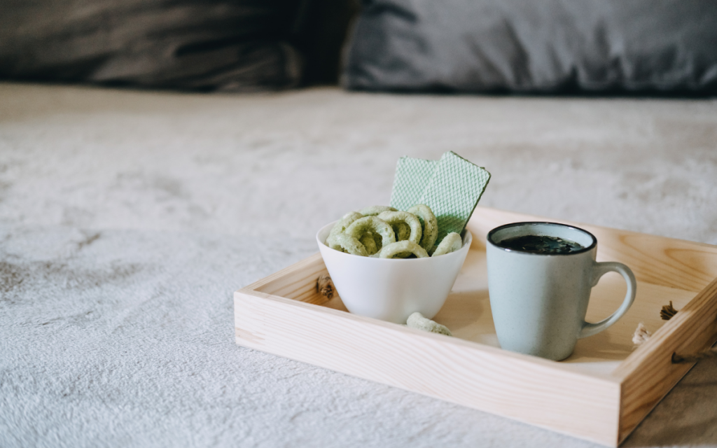 Medizinisches Cannabis in Keksform neben einer Tasse Hanftee auf einem Tablett