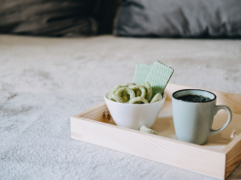 Medizinisches Cannabis in Keksform neben einer Tasse Hanftee auf einem Tablett