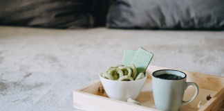 Medizinisches Cannabis in Keksform neben einer Tasse Hanftee auf einem Tablett