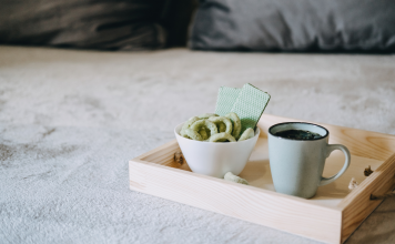 Medizinisches Cannabis in Keksform neben einer Tasse Hanftee auf einem Tablett