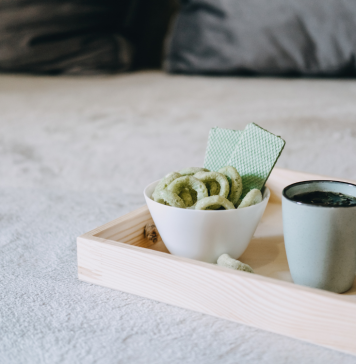 Medizinisches Cannabis in Keksform neben einer Tasse Hanftee auf einem Tablett