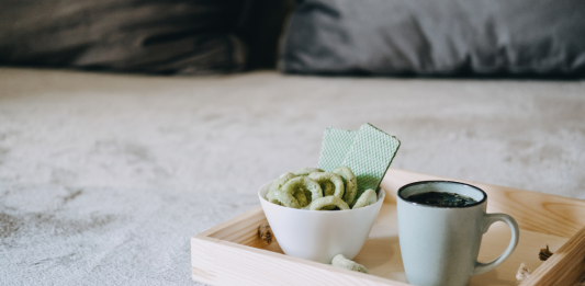 Medizinisches Cannabis in Keksform neben einer Tasse Hanftee auf einem Tablett
