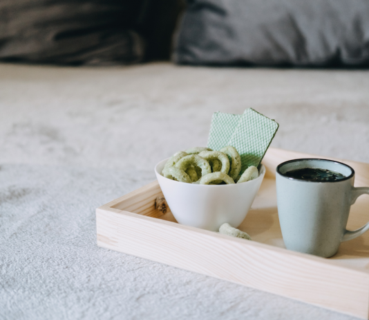 Medizinisches Cannabis in Keksform neben einer Tasse Hanftee auf einem Tablett