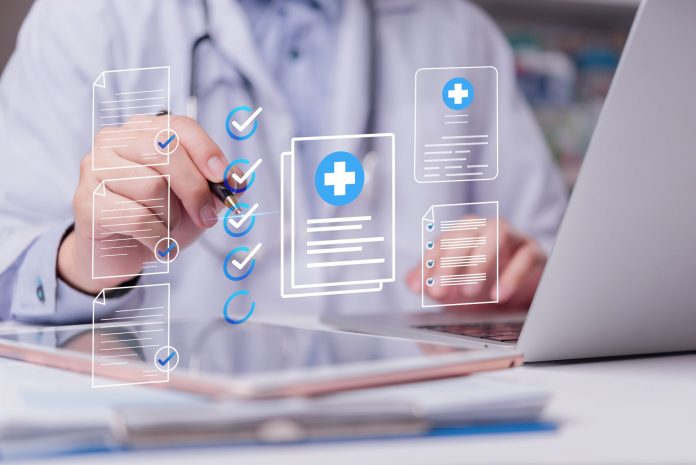Arzt oder Ärztin arbeitet am Laptop mit digitalen Gesundheitsdokumenten und Checklisten, symbolisch für strukturierte Online-Kommunikation und digitales Praxismanagement.