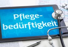 Tablet mit dem Schriftzug „Pflegebedürftigkeit“, Stethoskop, Medikamentenblister und Dokumente als Symbol für Pflegegrad und Pflegeleistungen.