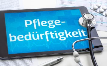 Tablet mit dem Schriftzug „Pflegebedürftigkeit“, Stethoskop, Medikamentenblister und Dokumente als Symbol für Pflegegrad und Pflegeleistungen.