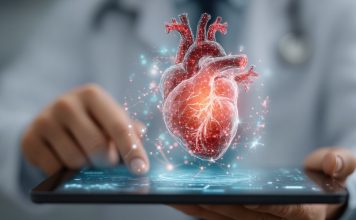 Digitale Herzdiagnostik in einer Praxissoftware: 3D-Darstellung eines menschlichen Herzens über einem Tablet, Symbol für Kardiologie, Telemedizin und digitale Patientenversorgung.