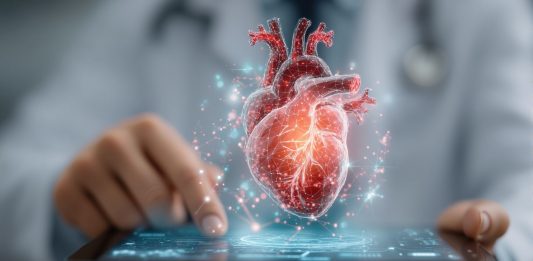 Digitale Herzdiagnostik in einer Praxissoftware: 3D-Darstellung eines menschlichen Herzens über einem Tablet, Symbol für Kardiologie, Telemedizin und digitale Patientenversorgung.