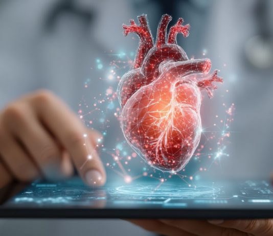 Digitale Herzdiagnostik in einer Praxissoftware: 3D-Darstellung eines menschlichen Herzens über einem Tablet, Symbol für Kardiologie, Telemedizin und digitale Patientenversorgung.