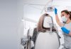 Vorsorge ist besser als Nachsorge – wie wichtig regelmäßige Besuche beim Zahnarzt sind Zahnärztin mit Maske und Handschuhen bereitet in einer hellen Praxis die zahnärztliche Untersuchung einer Patientin auf dem Behandlungsstuhl vor.