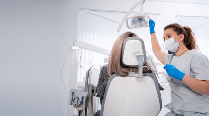 Vorsorge ist besser als Nachsorge – wie wichtig regelmäßige Besuche beim Zahnarzt sind Zahnärztin mit Maske und Handschuhen bereitet in einer hellen Praxis die zahnärztliche Untersuchung einer Patientin auf dem Behandlungsstuhl vor.